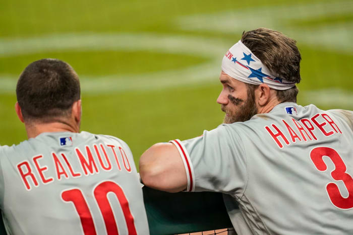 Phillies teammates Harper and Realmuto chat in the dugout.